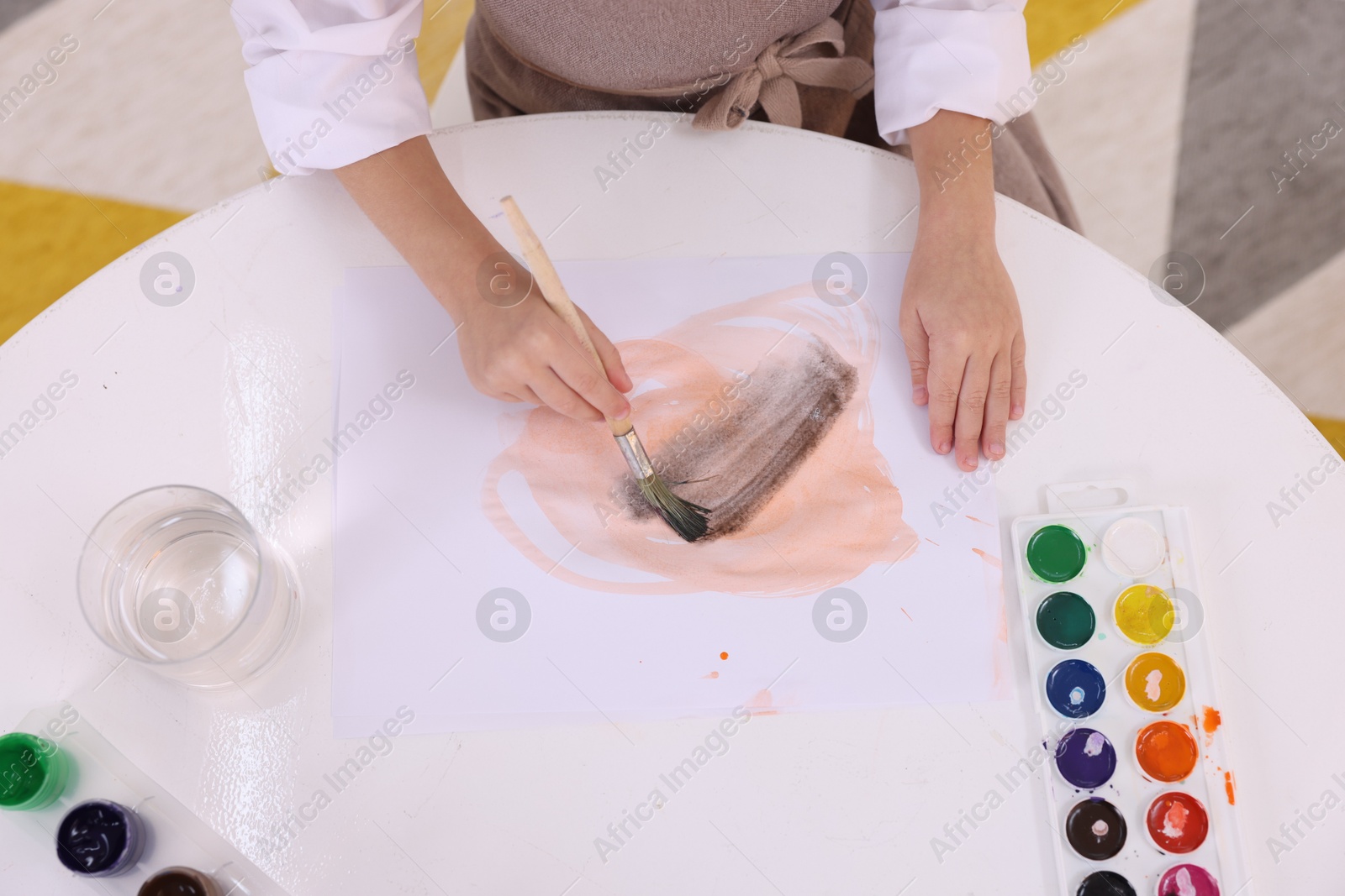 Photo of Girl drawing at white table indoors, closeup