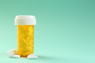 Photo of Medical bottle with antibiotic pills on yellow background. Space for text