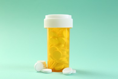 Photo of Medical bottle with antibiotic pills on yellow background