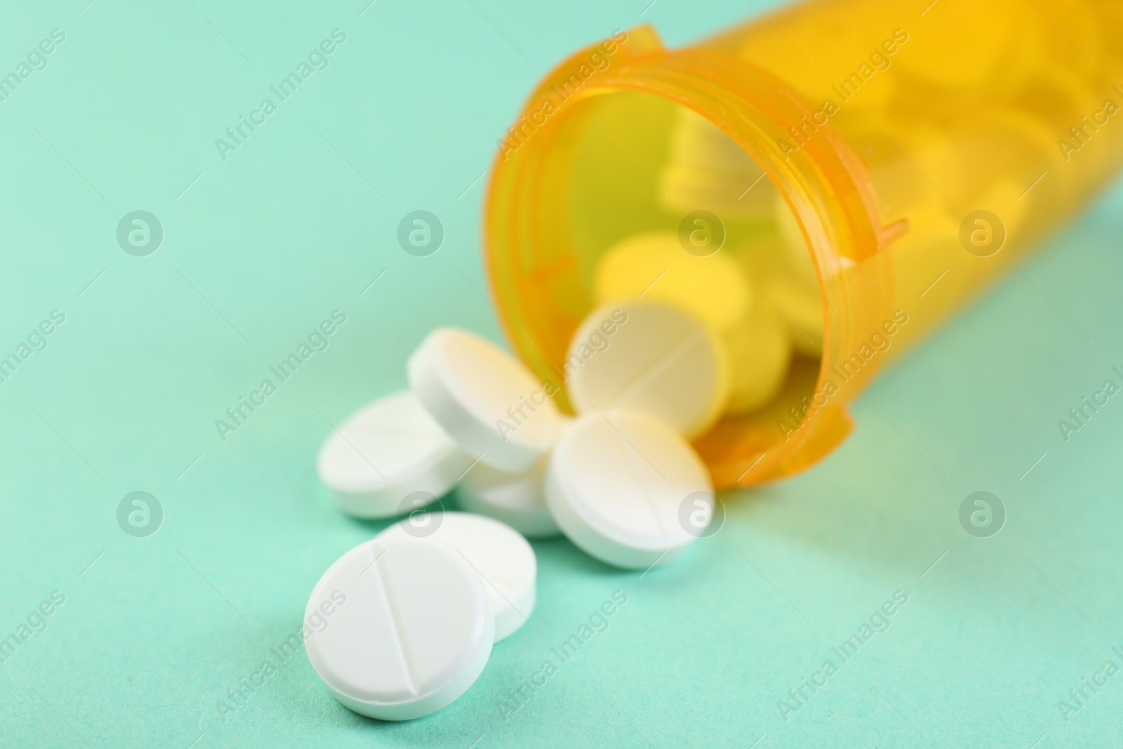 Photo of Medical bottle with antibiotic pills on yellow background, closeup