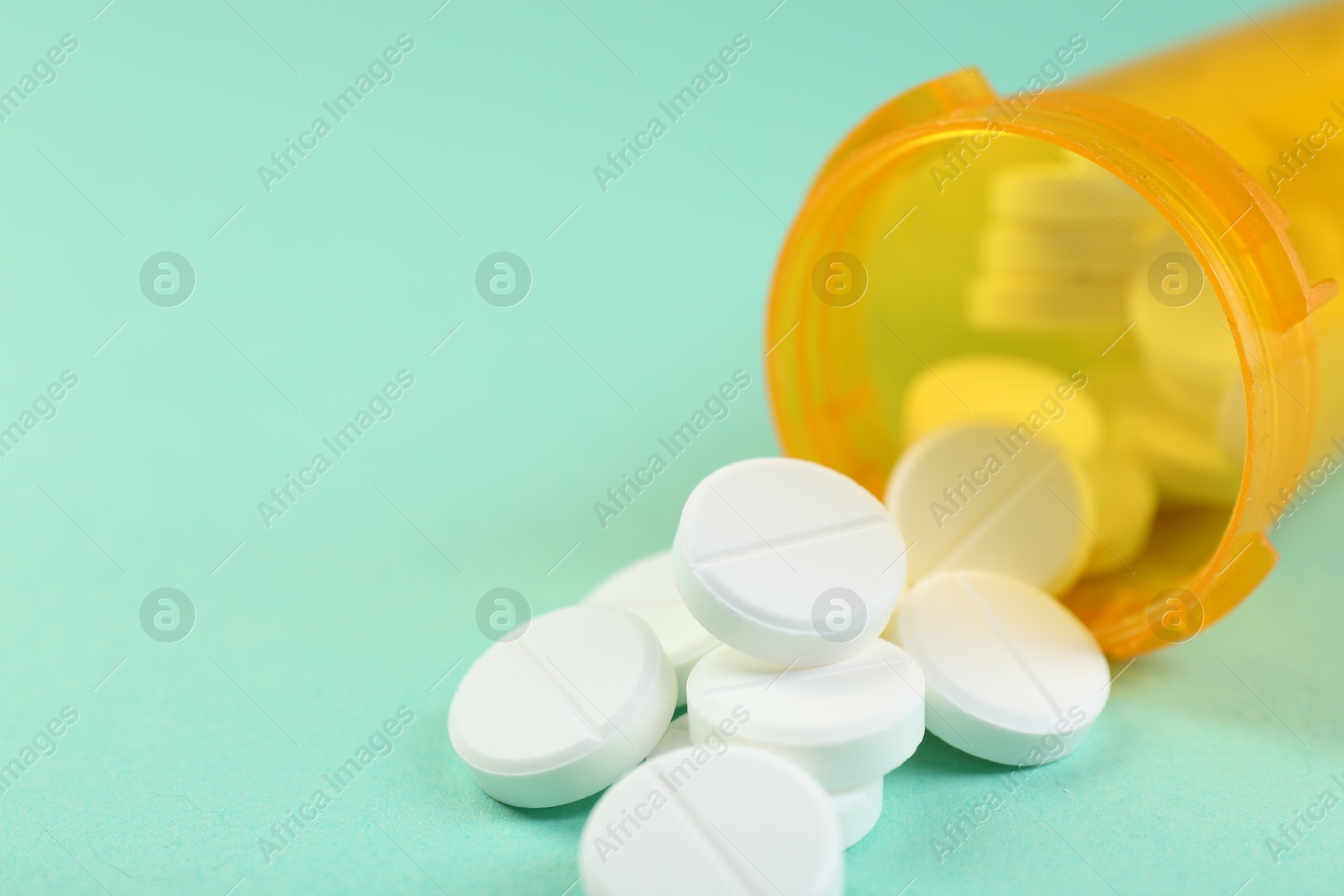 Photo of Medical bottle with antibiotic pills on yellow background, closeup. Space for text