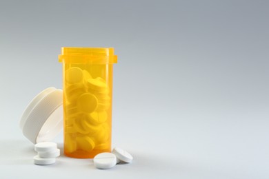 Photo of Medical bottle with antibiotic pills on grey background. Space for text