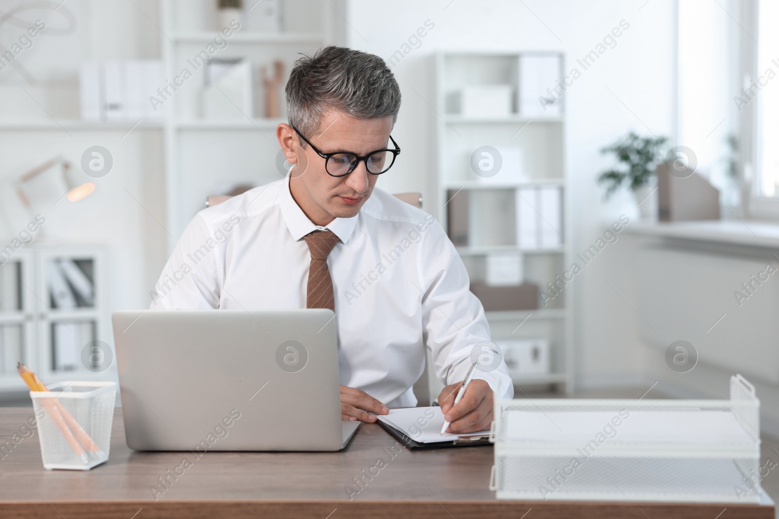 Photo of Middle aged man working at table in office