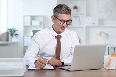 Middle aged man working at table in office