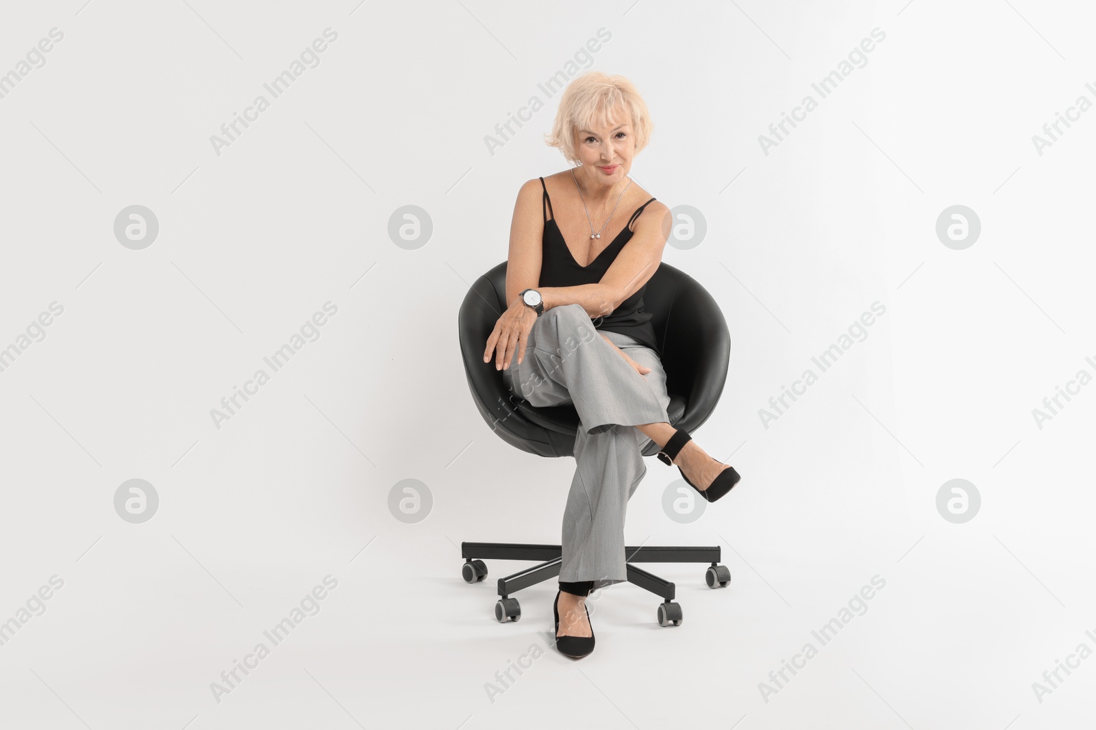 Photo of Beautiful senior woman sitting on chair against white background