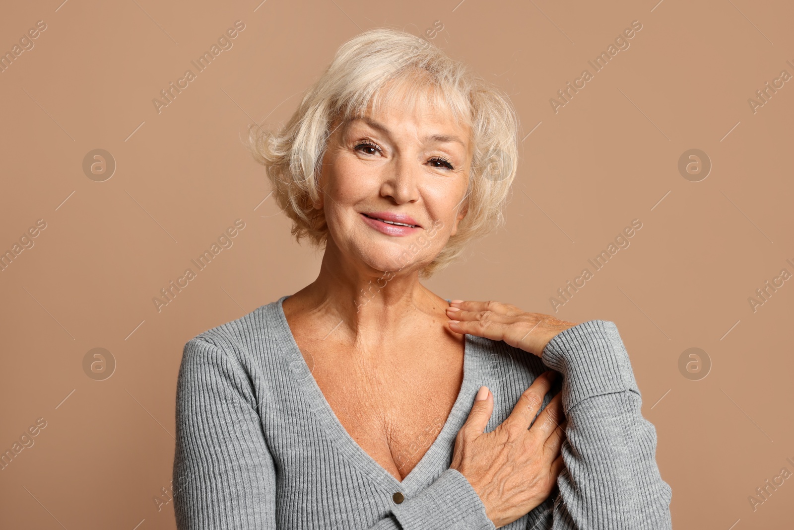 Photo of Portrait of beautiful senior woman on light brown background