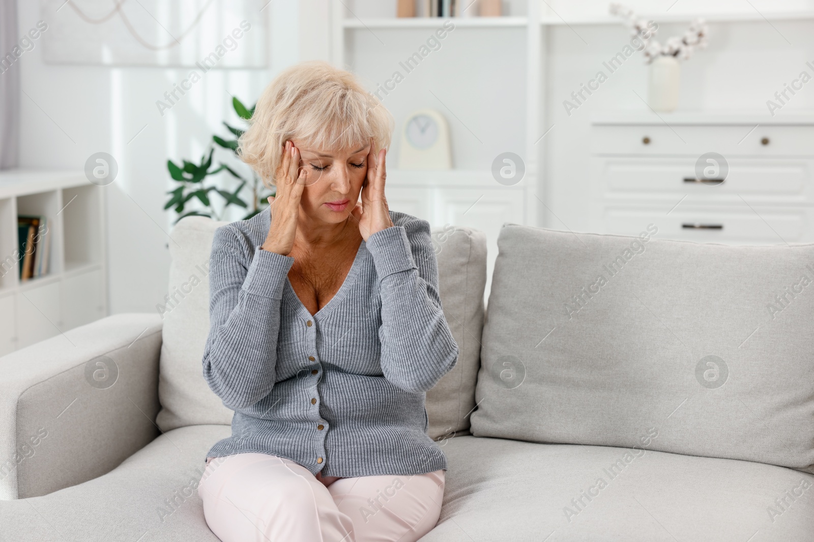 Photo of Beautiful senior woman suffering from headache at home