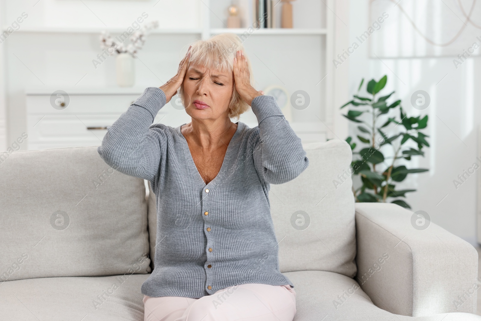 Photo of Beautiful senior woman suffering from headache at home