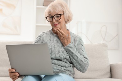 Photo of Beautiful senior woman using laptop at home