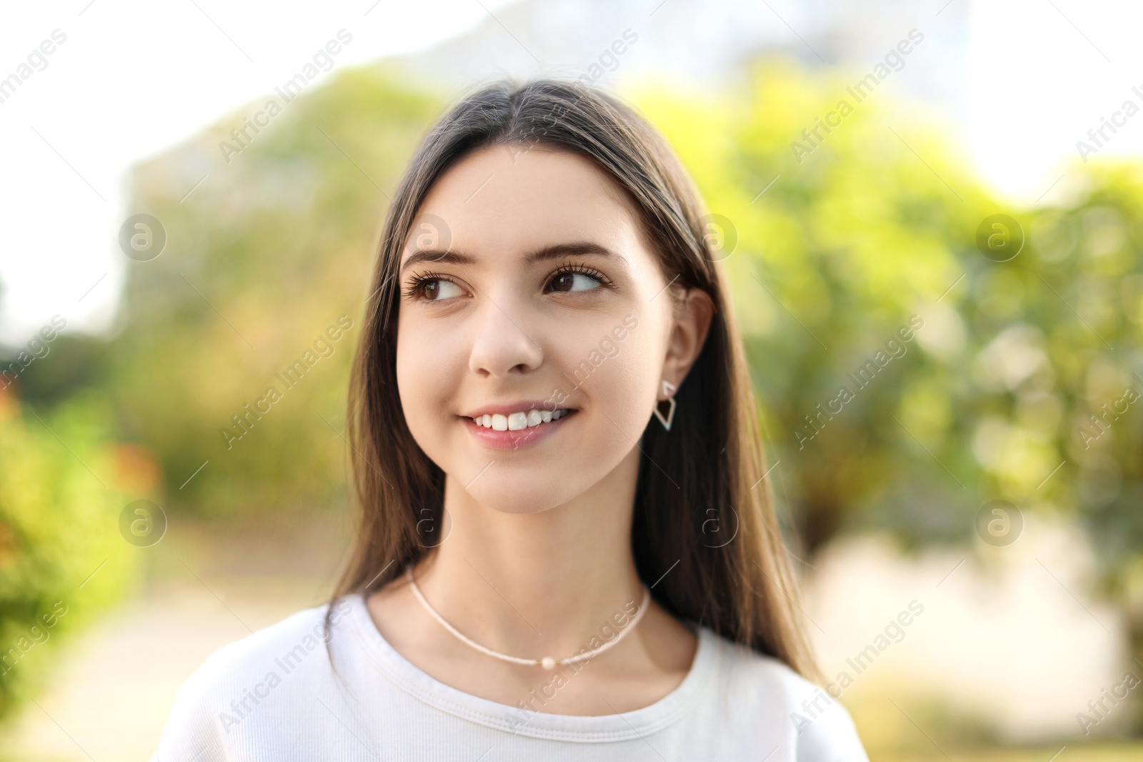 Photo of Portrait of smiling teenage girl on city street