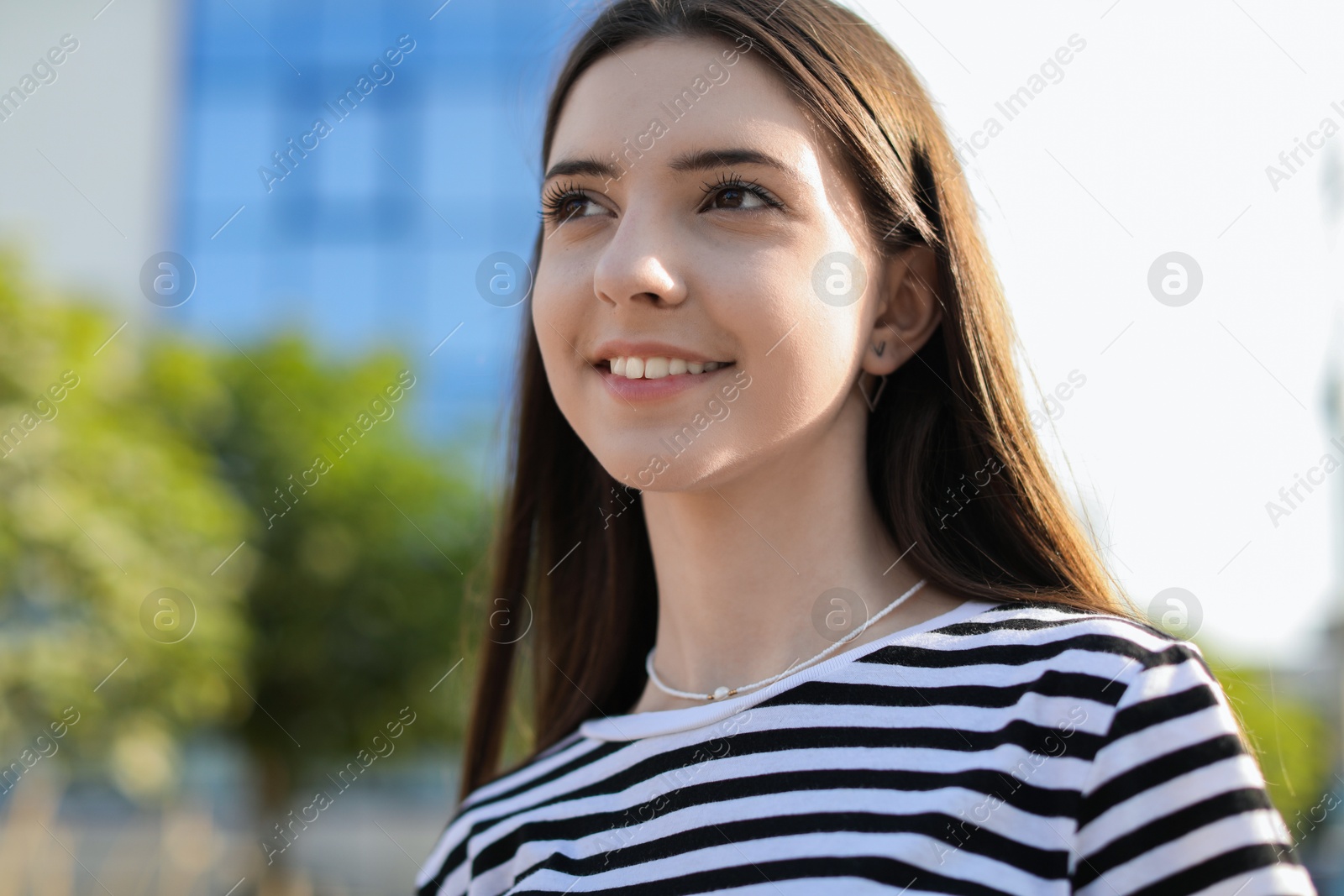 Photo of Portrait of smiling teenage girl on city street