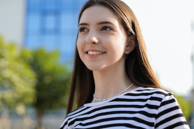 Photo of Portrait of smiling teenage girl on city street