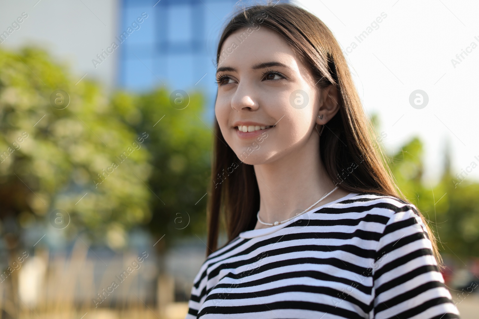 Photo of Portrait of smiling teenage girl outdoors. Space for text