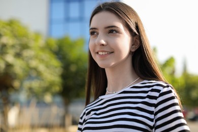 Photo of Portrait of smiling teenage girl outdoors. Space for text