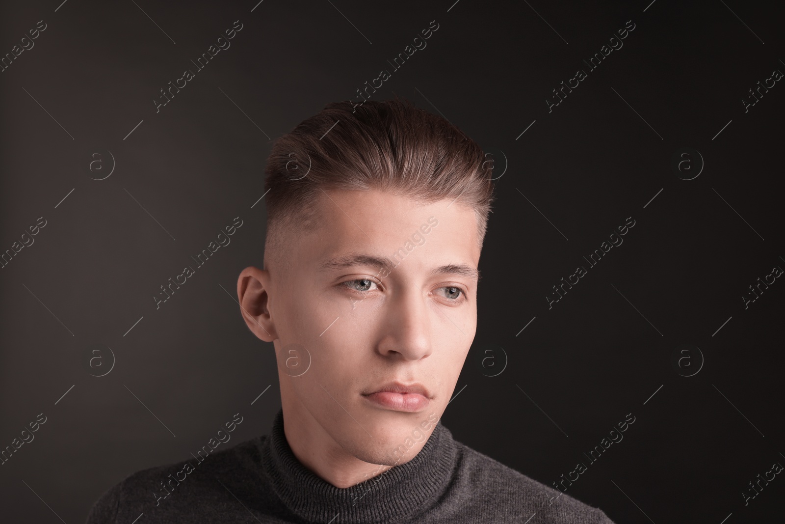 Photo of Handsome young man with stylish haircut on black background