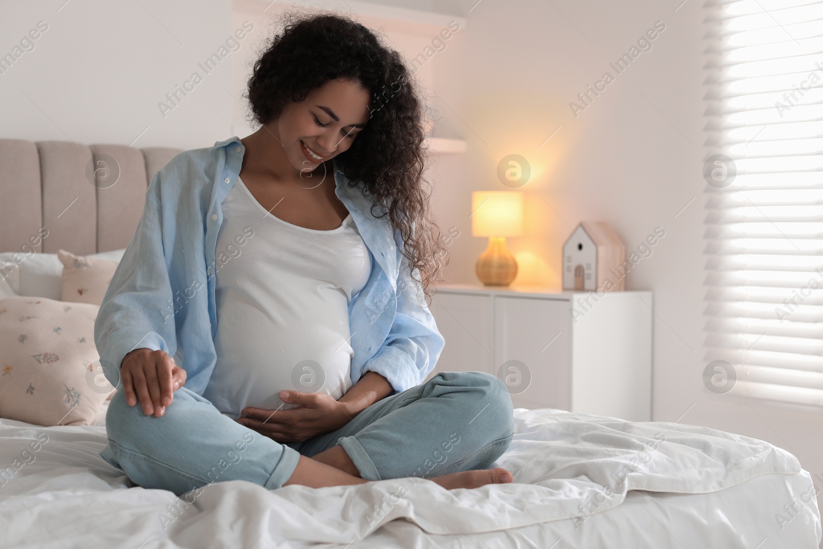 Photo of Portrait of beautiful pregnant woman on bed at home