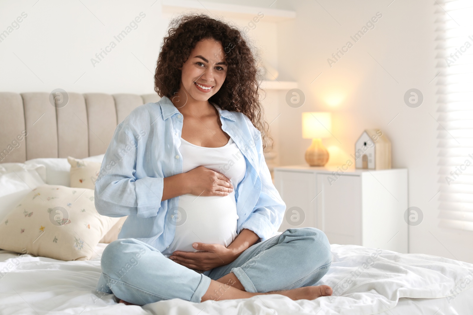 Photo of Portrait of beautiful pregnant woman on bed at home