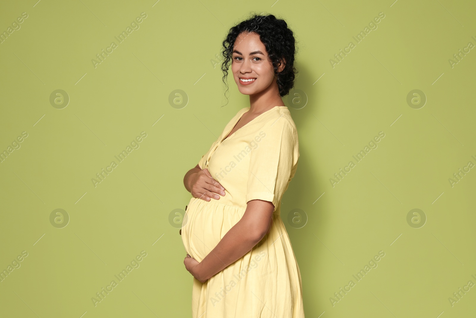 Photo of Portrait of beautiful pregnant woman on green background