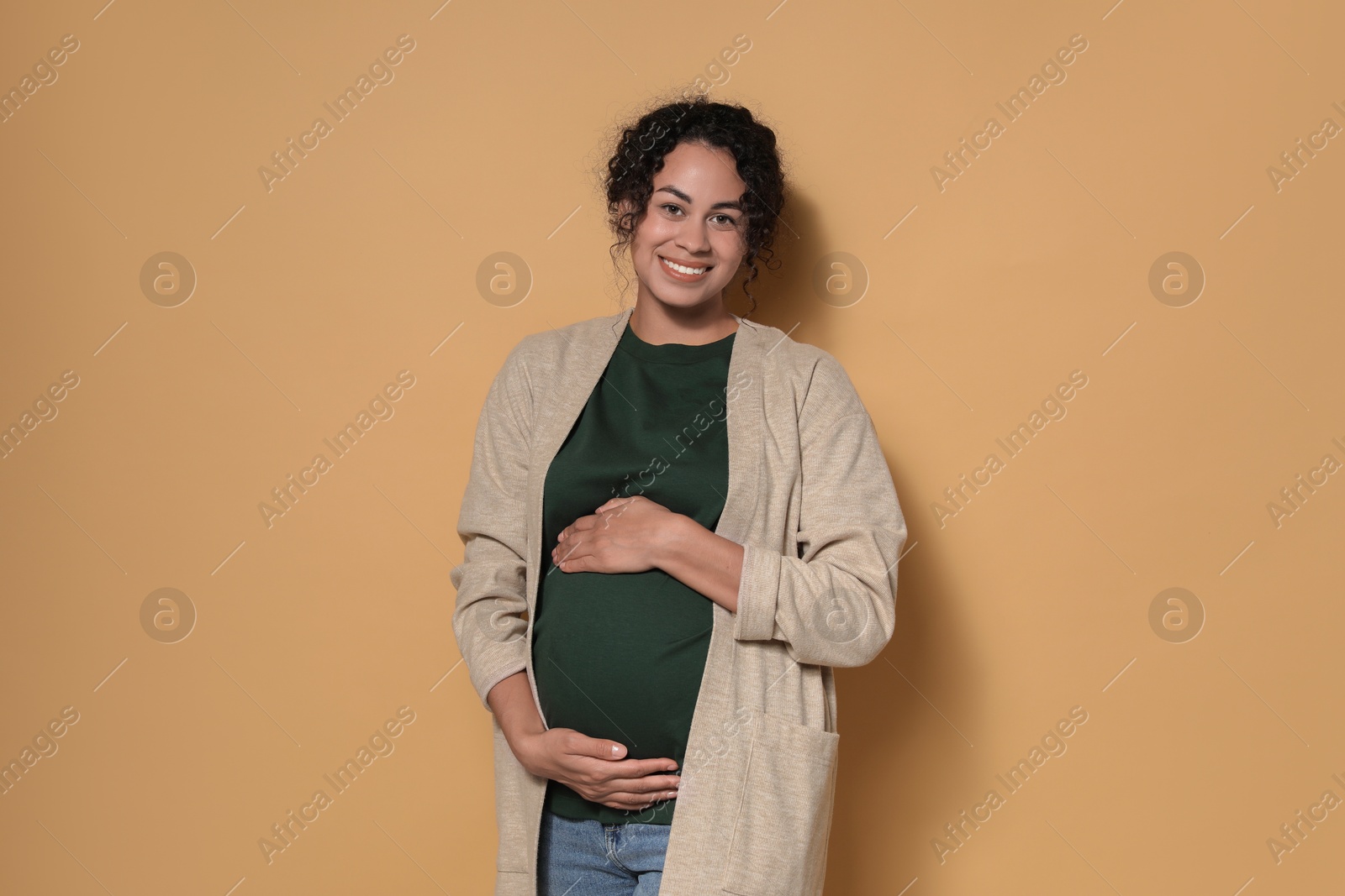 Photo of Portrait of beautiful pregnant woman on beige background