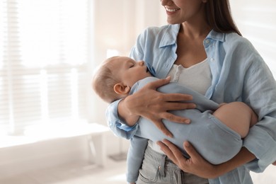 Photo of Mother holding her sleeping baby at home, closeup. Space for text