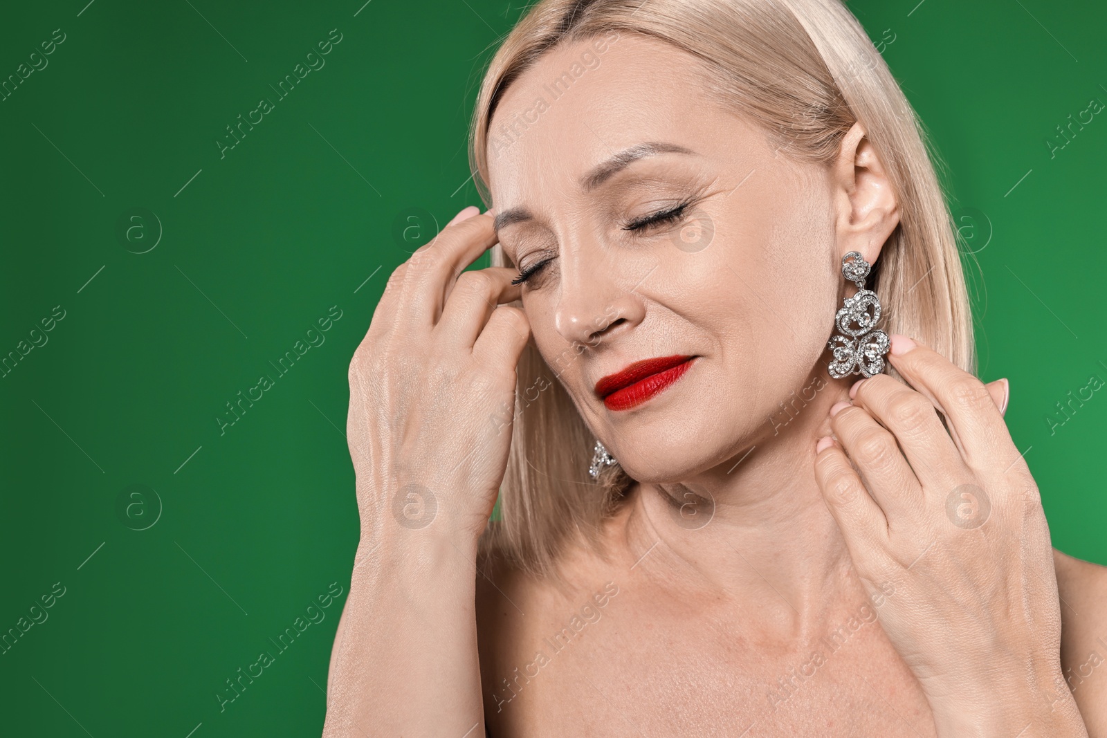 Photo of Woman with perfect makeup on green background. Space for text