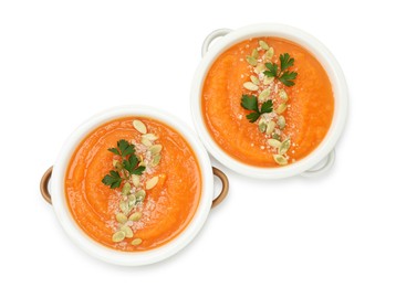 Photo of Delicious sweet potato soup with pumpkin seeds and parsley in bowls isolated on white, top view