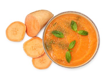 Photo of Delicious sweet potato soup with basil in bowl and fresh vegetable isolated on white, top view