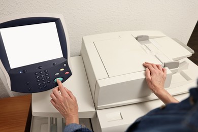 Photo of Woman using modern printer indoors, closeup. Printing house