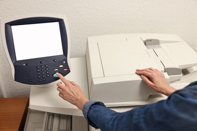 Photo of Woman using modern printer indoors, closeup. Printing house