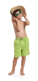 Photo of Little boy in beachwear, sunglasses and straw hat on white background