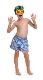 Photo of Little boy in beachwear and sunglasses on white background