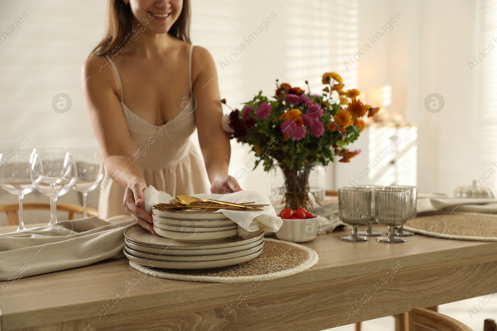 Photo of Woman setting table for dinner at home, closeup