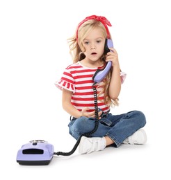 Cute little girl with telephone on white background