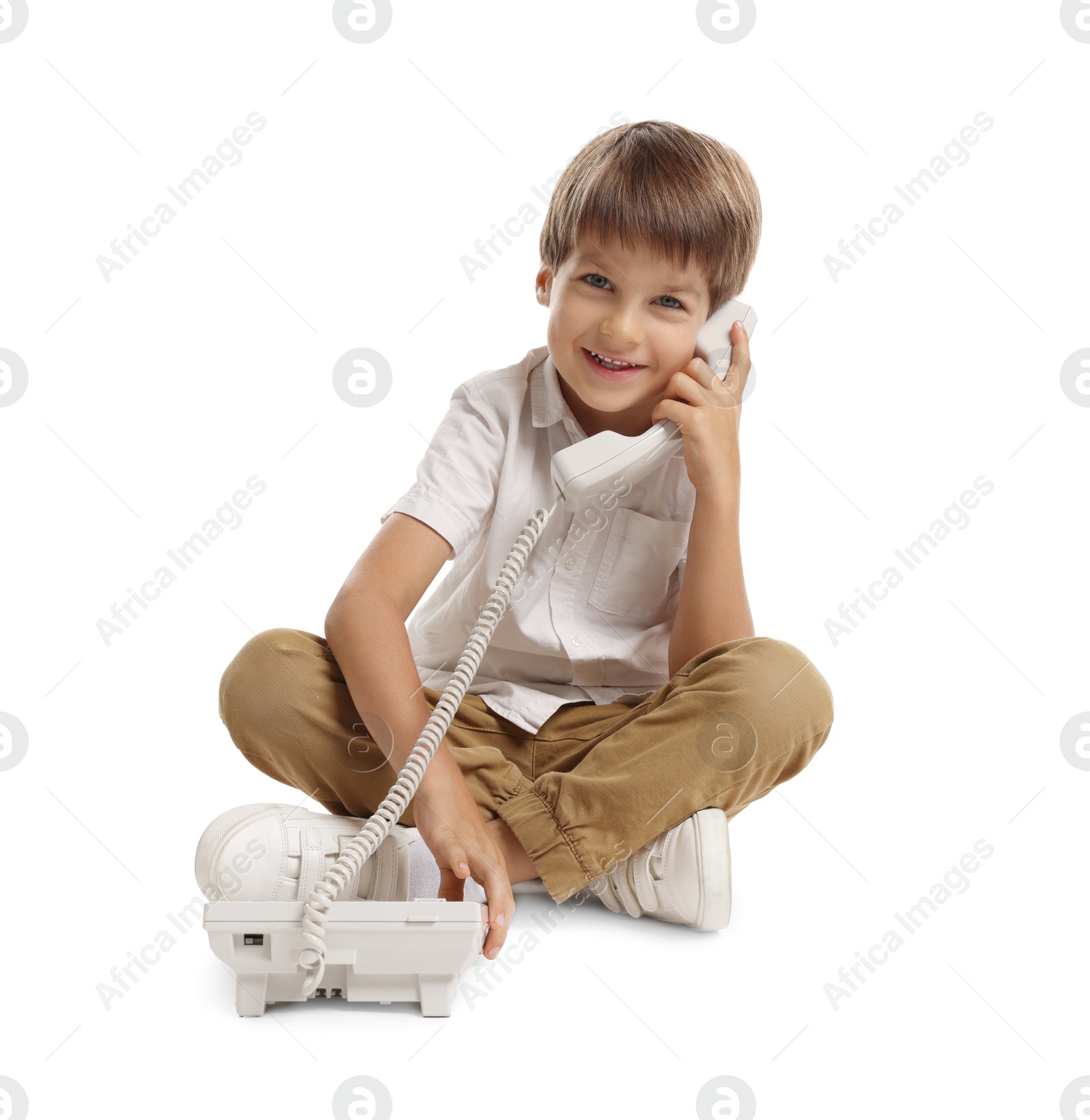 Photo of Cute little boy with telephone on white background