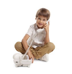 Photo of Cute little boy with telephone on white background