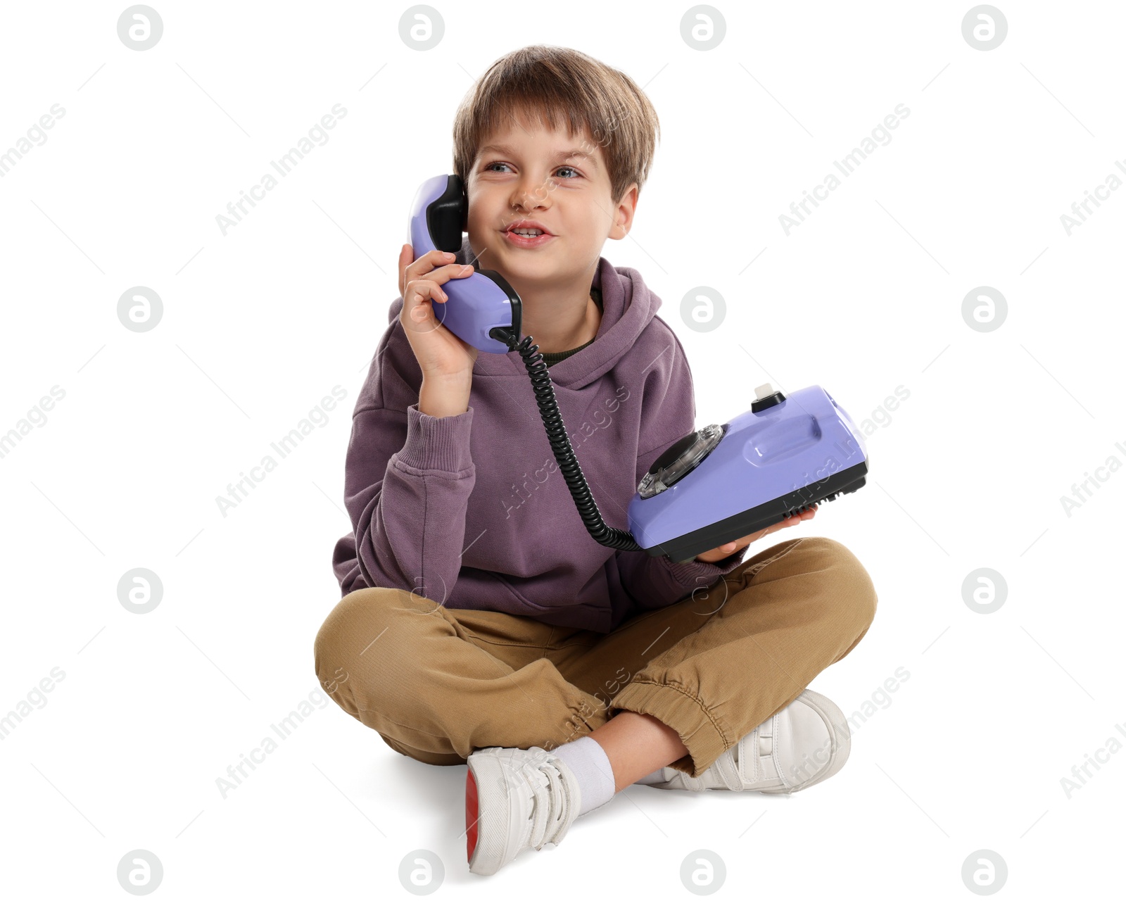 Photo of Cute little boy with old telephone on white background