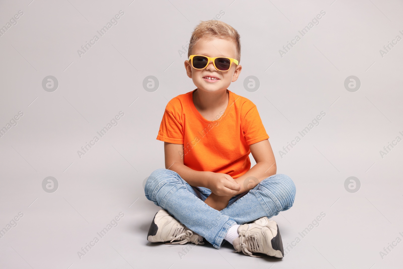 Photo of Little boy with sunglasses on light grey background