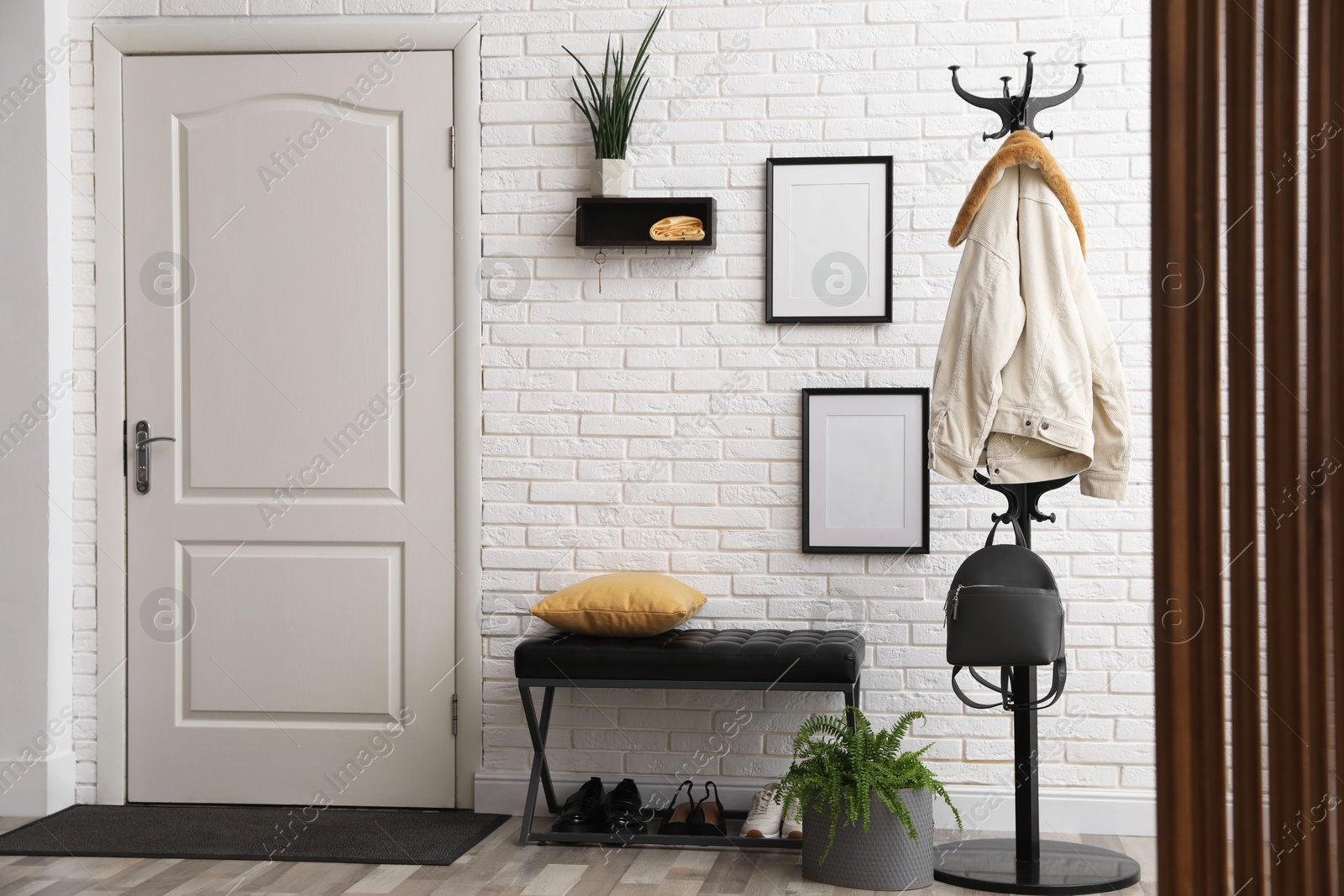 Photo of Stylish hallway interior with coat rack and bench