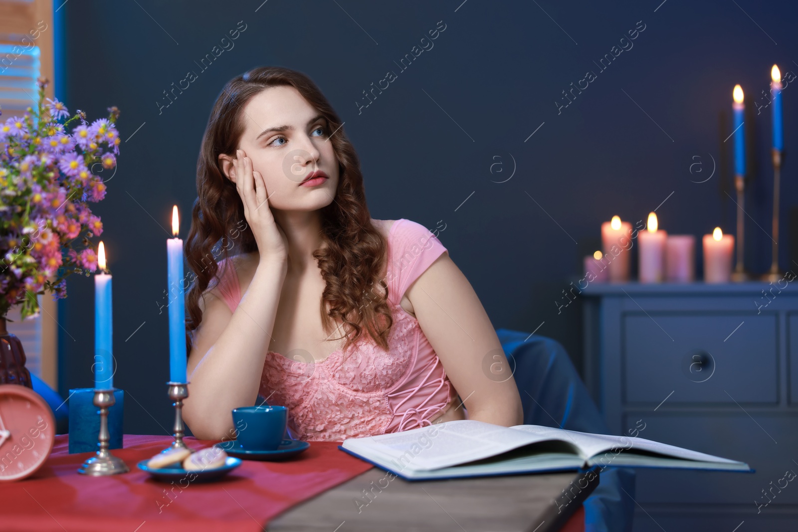 Photo of Beautiful young woman sitting at table in room. Fashion vintage style portrait