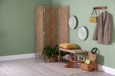 Photo of Stylish hallway interior with bench and folding screen