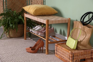 Photo of Bench with shoes near green wall in hallway