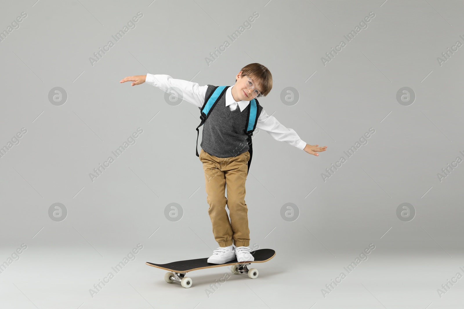 Photo of Little boy with skateboard on light grey background