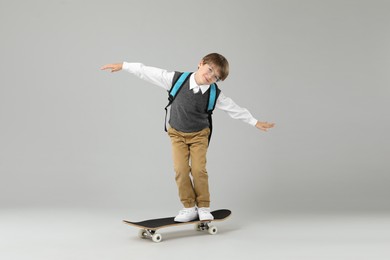 Photo of Little boy with skateboard on light grey background