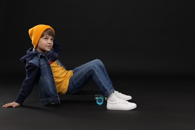 Photo of Little boy with skateboard on black background