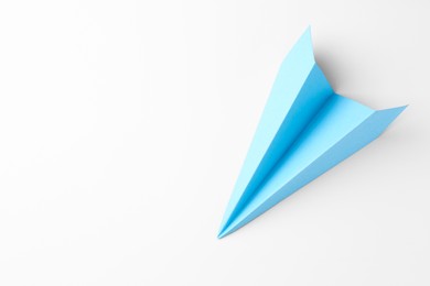 Photo of One handmade light blue paper plane on white background, top view. Space for text