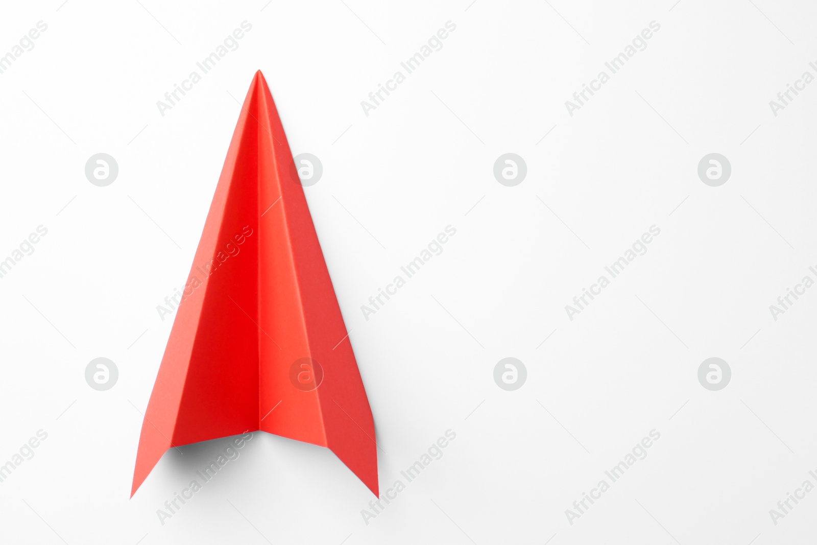 Photo of One handmade coral paper plane on white background, top view. Space for text