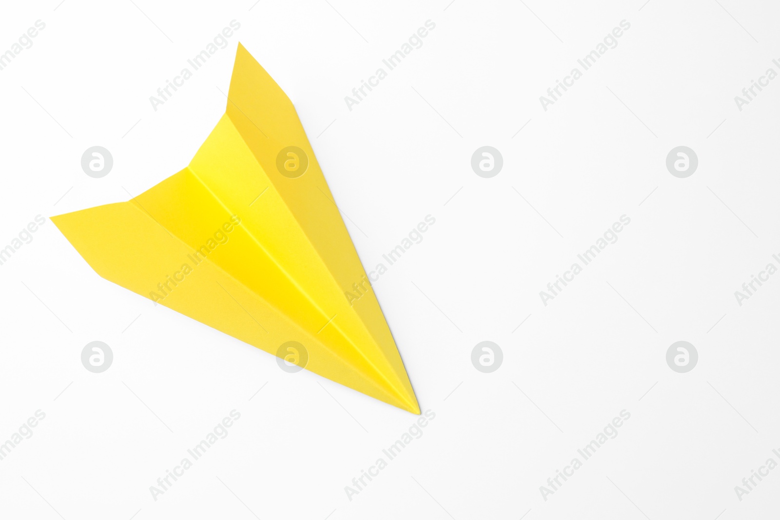 Photo of One handmade yellow paper plane on white background, top view. Space for text