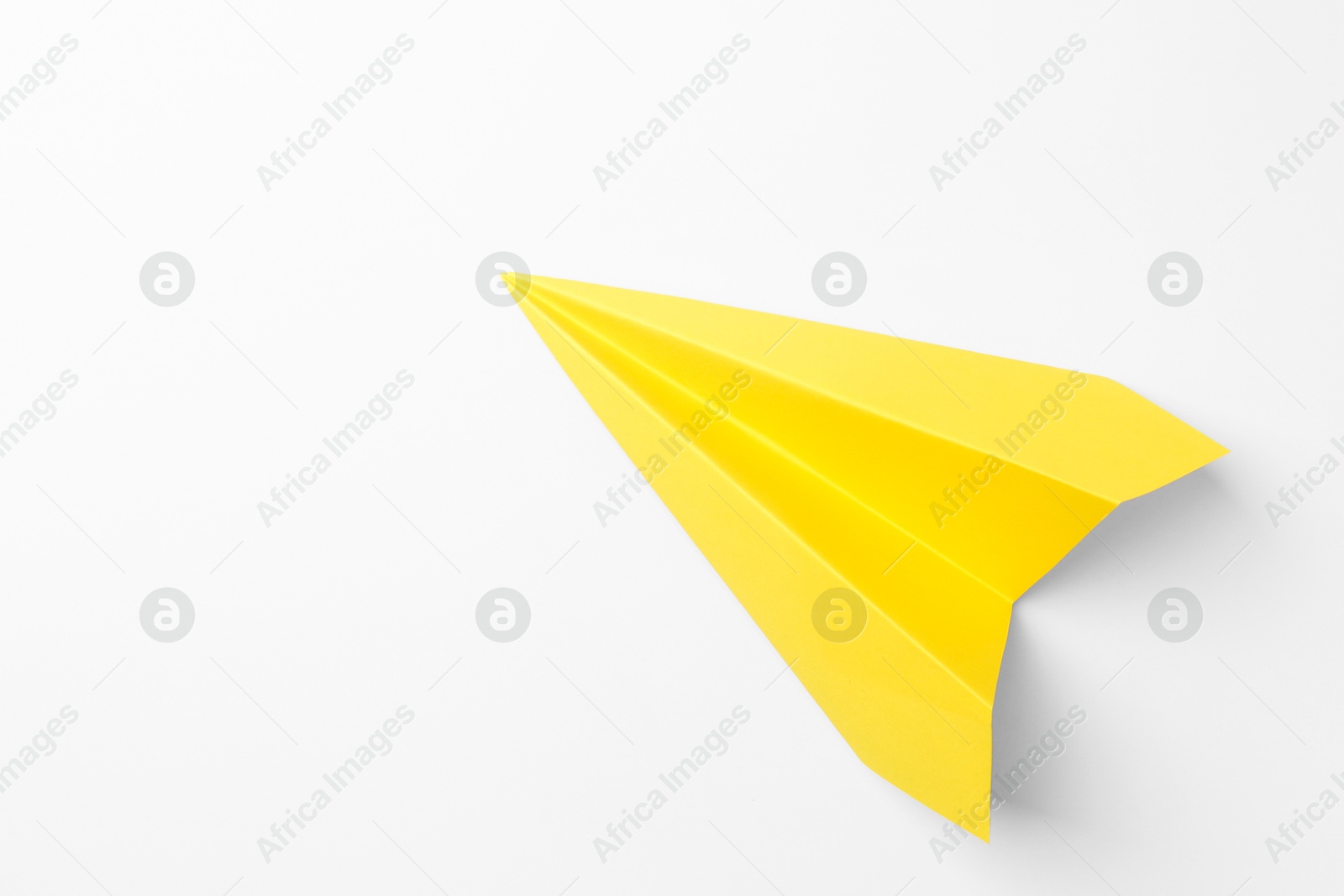 Photo of One handmade yellow paper plane on white background, top view. Space for text