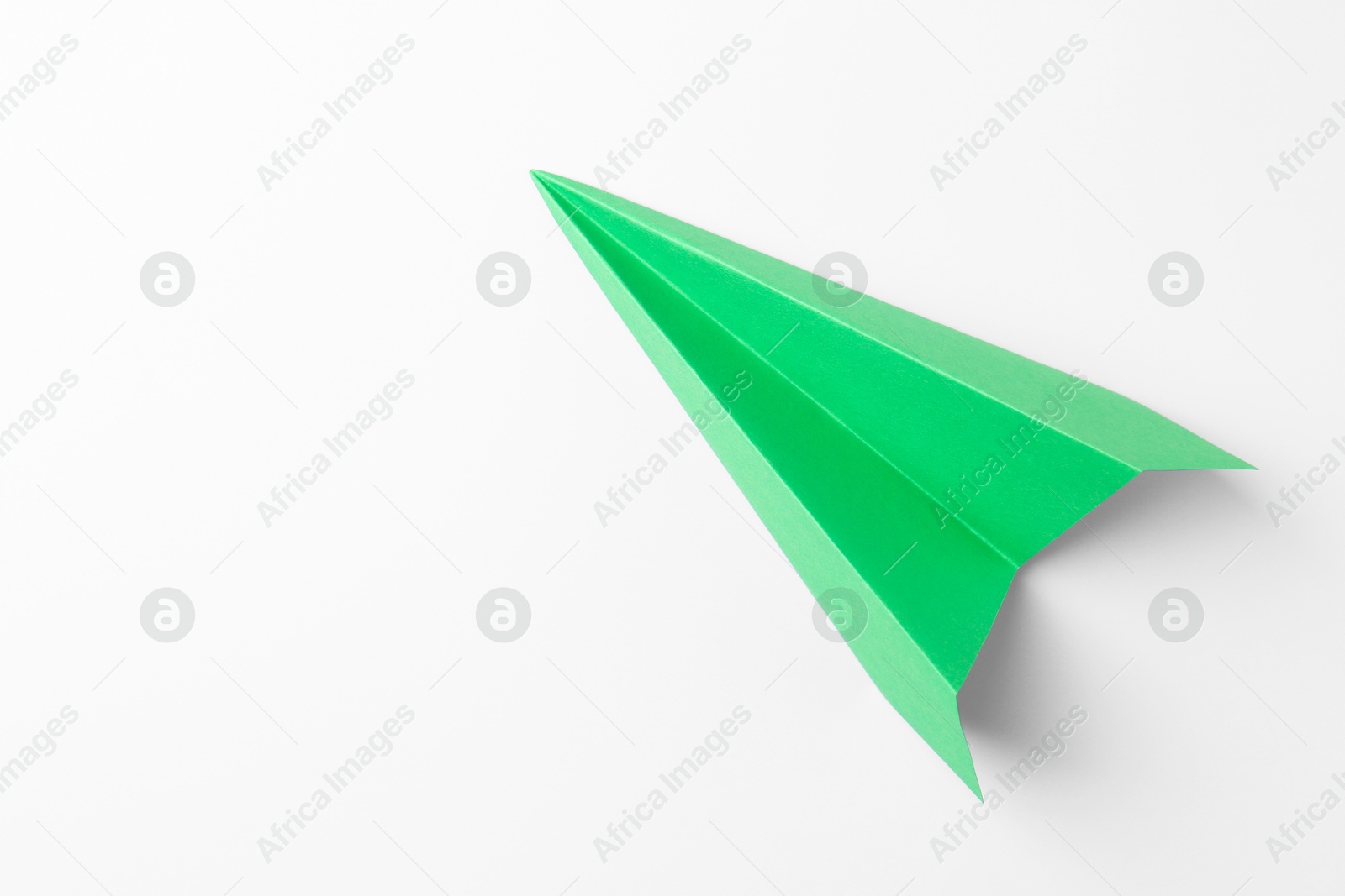 Photo of One handmade green paper plane on white background, top view. Space for text