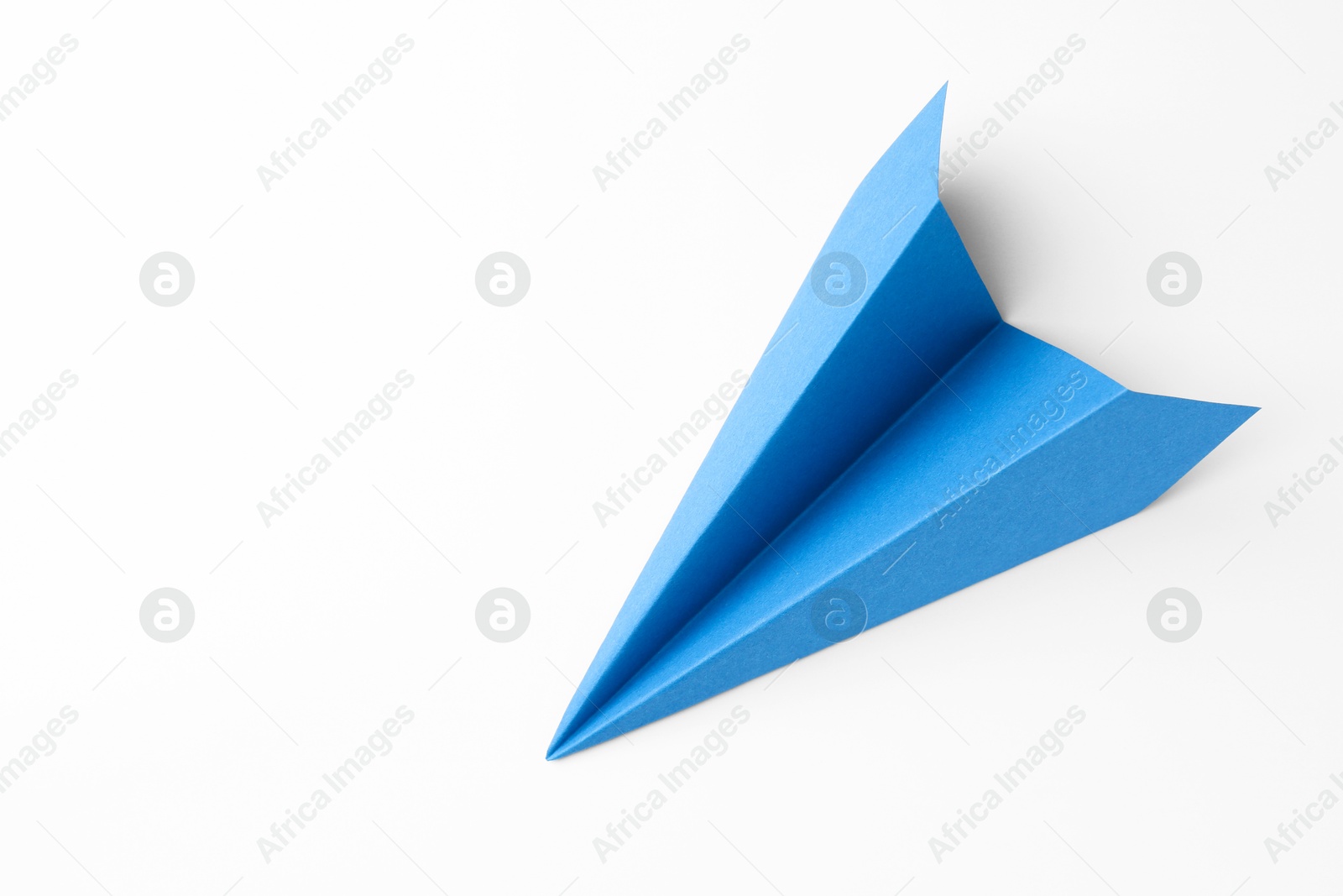 Photo of One handmade light blue paper plane on white background, top view. Space for text